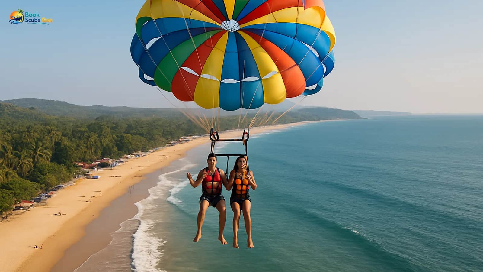 Parasail canopy lifting riders above a Goa beach